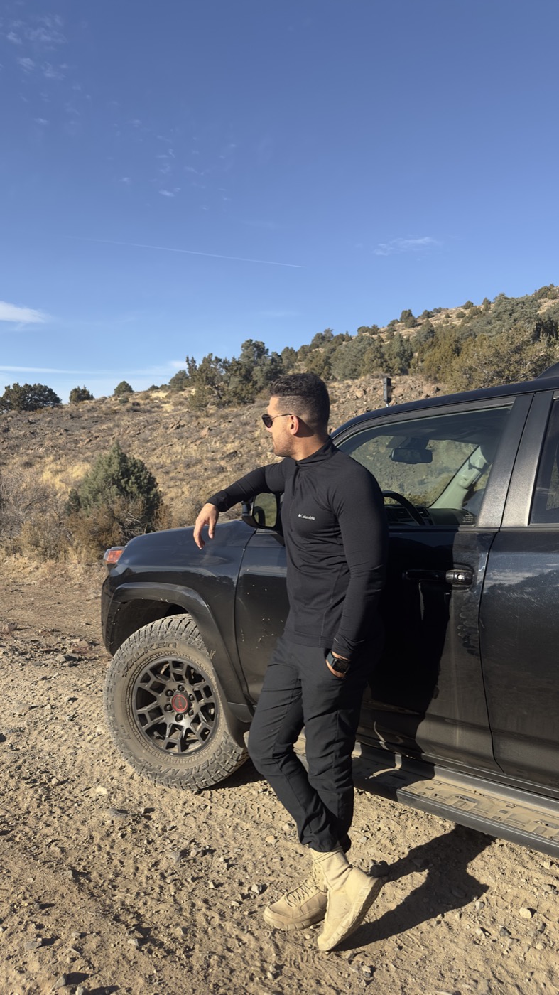 Hayden leaning against his 4Runner on a desert trail